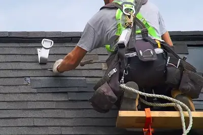 Roofer replacing damaged shingles